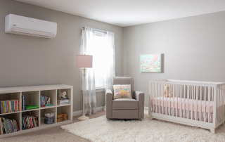 Ductless heating and cooling system hangs above dresser in a nursery.