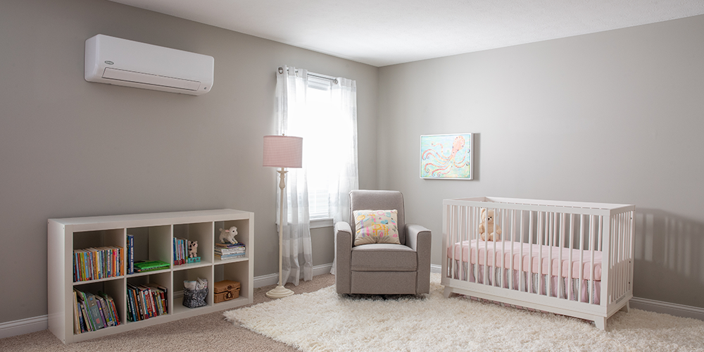 Ductless heating and cooling system hangs above dresser in a nursery.